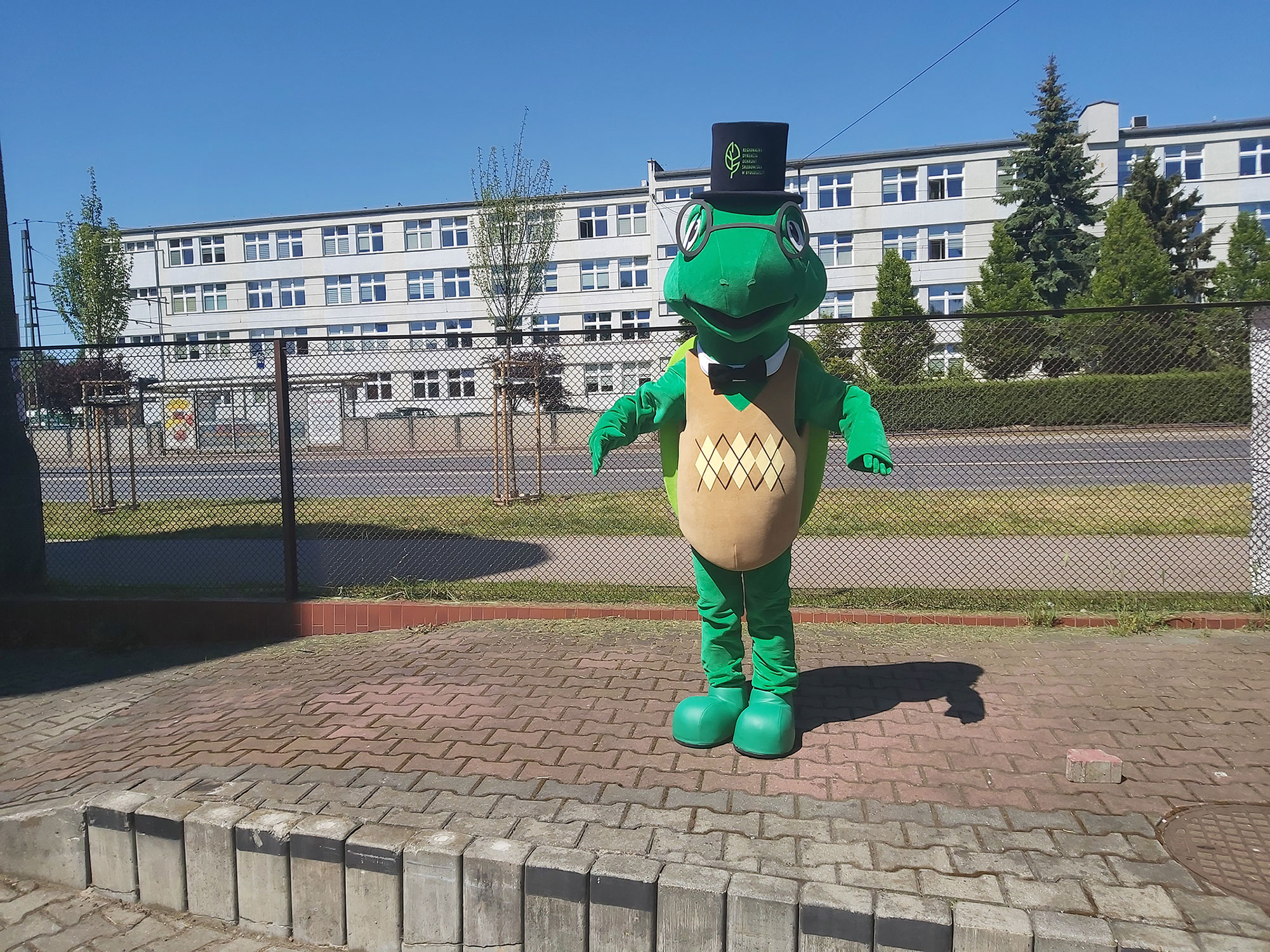 Do fotografii pozuje kostium reklamowy w postaci żółwia przed siedzibą firmy Elabika